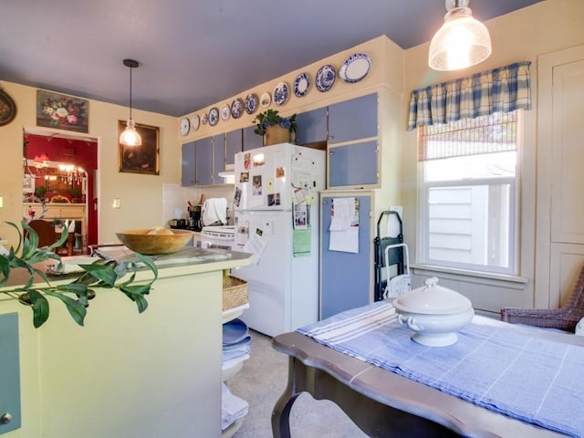 kitchen with hanging light fixtures and freestanding refrigerator