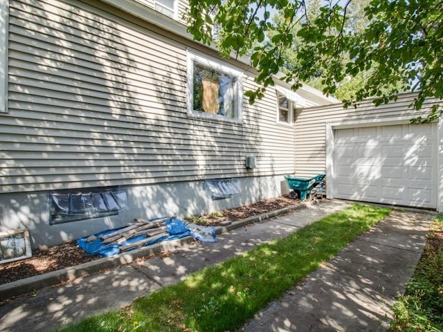 view of property exterior featuring an outdoor structure, a garage, driveway, and crawl space