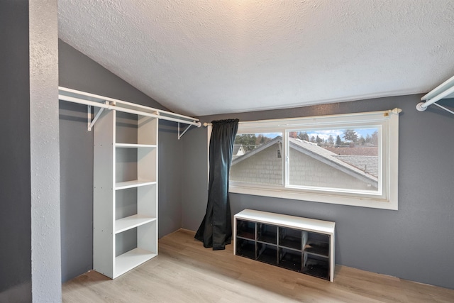 walk in closet featuring lofted ceiling and wood finished floors