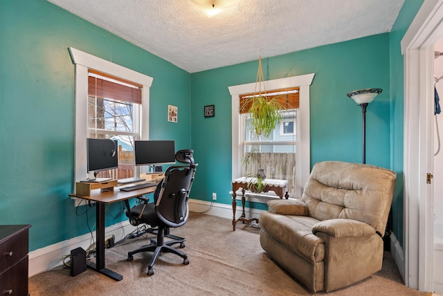 office with carpet flooring, baseboards, and a textured ceiling