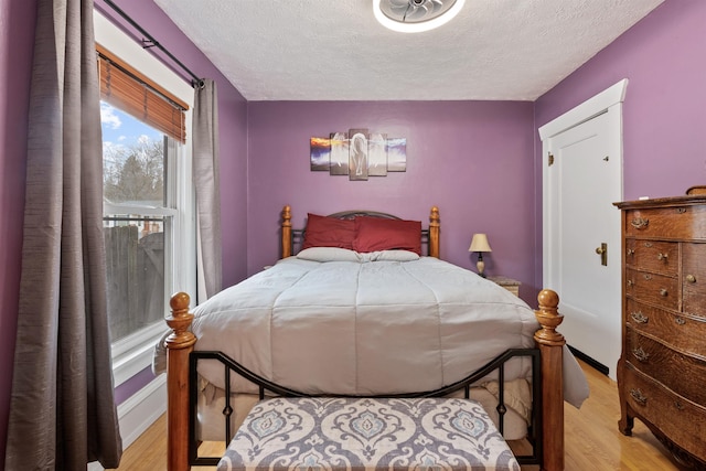 bedroom with light wood-style floors and a textured ceiling