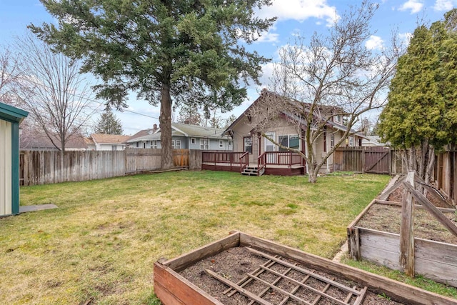 view of yard featuring a garden, a fenced backyard, and a wooden deck