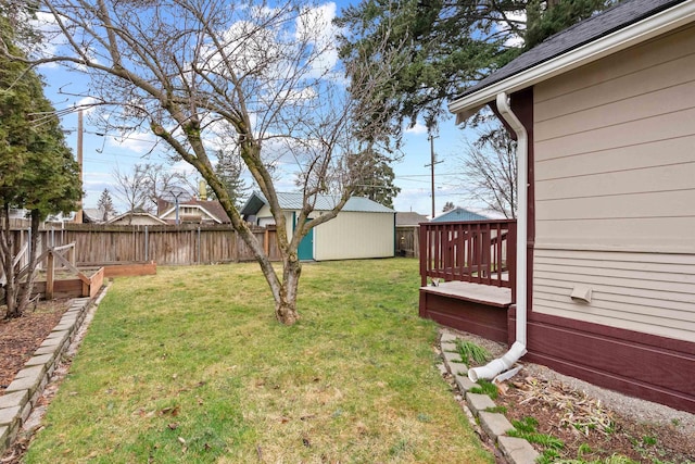 view of yard featuring a vegetable garden, a storage unit, an outdoor structure, and fence