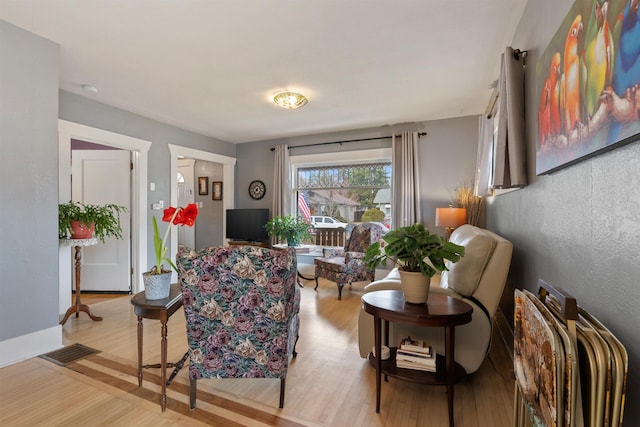 living area with light wood-style floors and visible vents