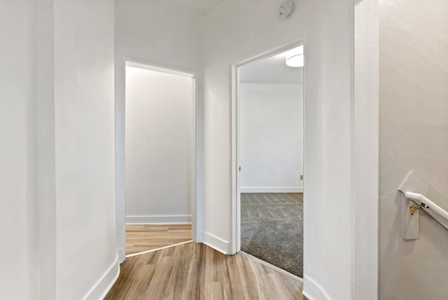 corridor with baseboards and wood finished floors