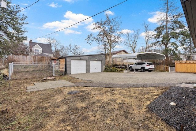 view of yard featuring a detached carport, an outdoor structure, fence, and driveway