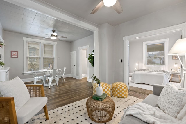 living room with plenty of natural light, baseboards, ceiling fan, and wood finished floors