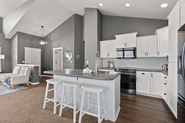 kitchen featuring dark countertops, white cabinets, and appliances with stainless steel finishes