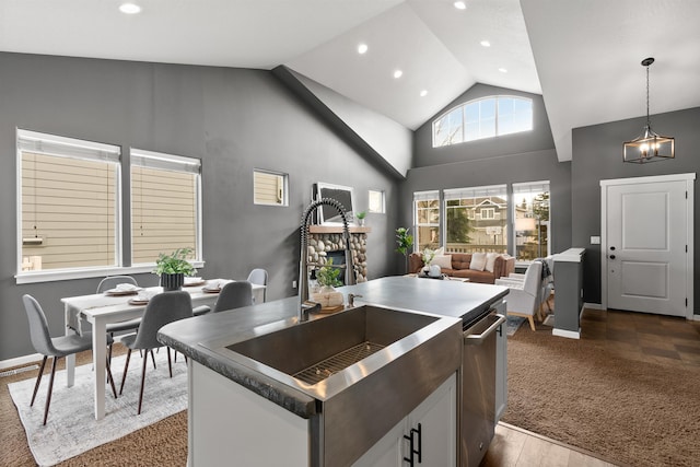 kitchen featuring high vaulted ceiling, recessed lighting, a sink, hanging light fixtures, and open floor plan