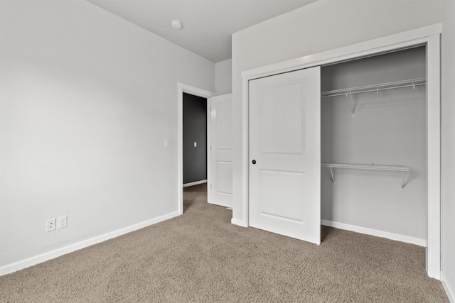 unfurnished bedroom with a closet, baseboards, and carpet floors