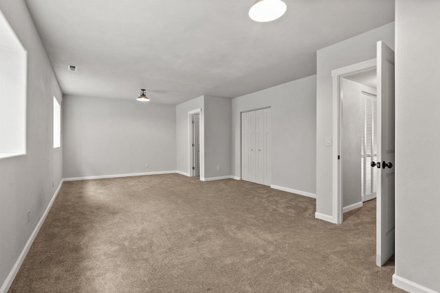 unfurnished room featuring visible vents, baseboards, and carpet