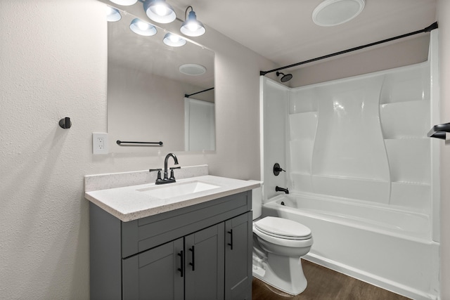 bathroom featuring washtub / shower combination, toilet, wood finished floors, and vanity