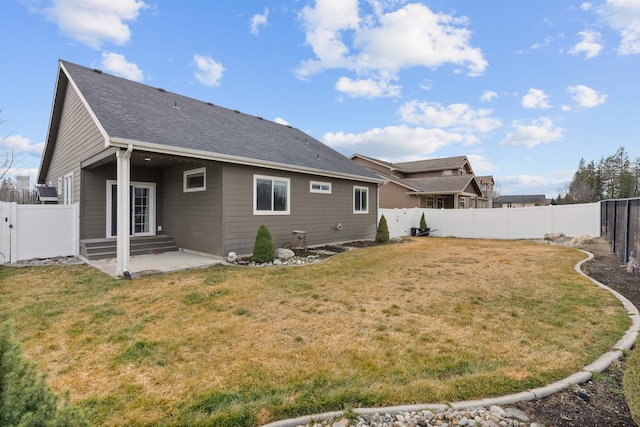 rear view of house with a lawn, entry steps, a fenced backyard, and a patio