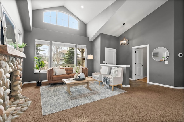 living area featuring high vaulted ceiling, baseboards, a stone fireplace, and carpet