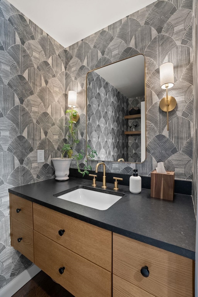 bathroom with vanity and wallpapered walls