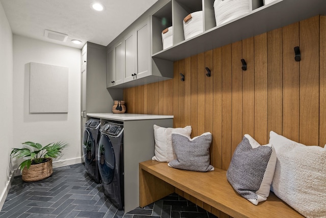 clothes washing area featuring baseboards, washer and clothes dryer, recessed lighting, brick floor, and cabinet space