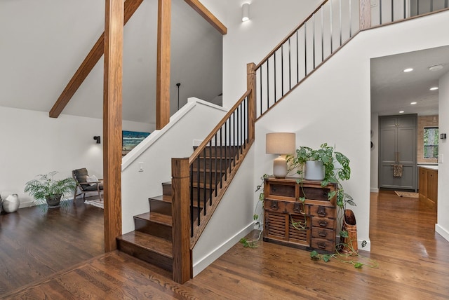 staircase with recessed lighting, baseboards, high vaulted ceiling, and wood finished floors