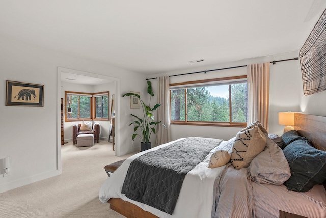 bedroom featuring visible vents, multiple windows, baseboards, and carpet floors