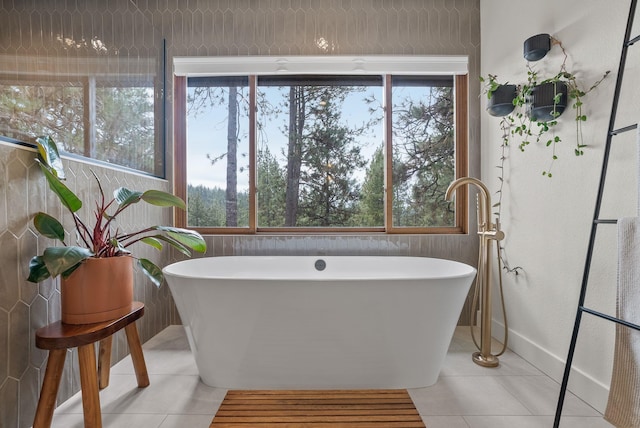 full bathroom featuring tile patterned floors and a freestanding tub