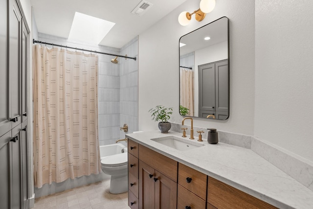 full bathroom with visible vents, toilet, a skylight, shower / bath combination with curtain, and vanity