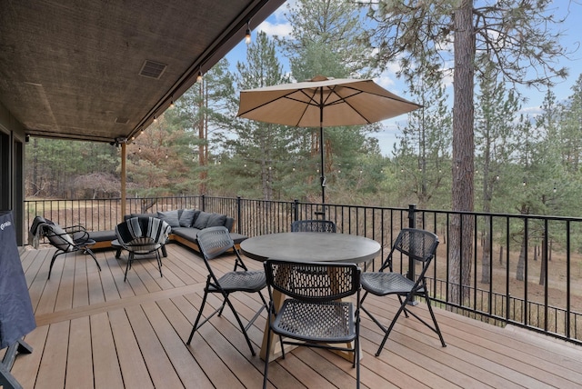 wooden deck with outdoor dining space and an outdoor hangout area