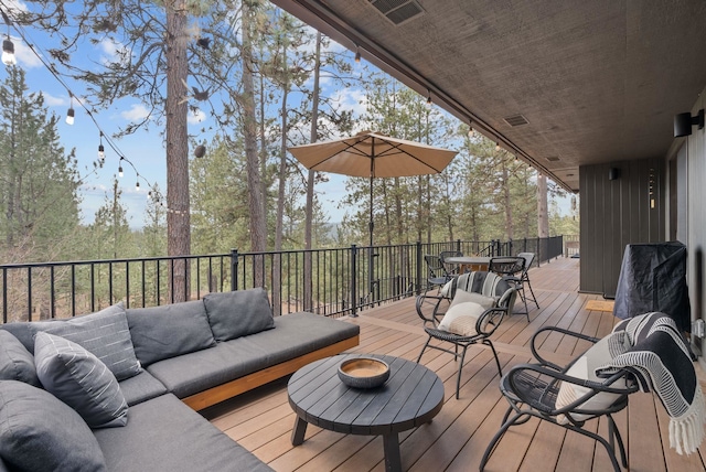 wooden terrace featuring visible vents, an outdoor living space, and outdoor dining area