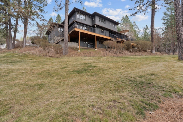 rear view of house with a deck and a yard