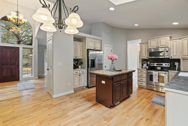 kitchen featuring a chandelier, backsplash, appliances with stainless steel finishes, and light wood-type flooring