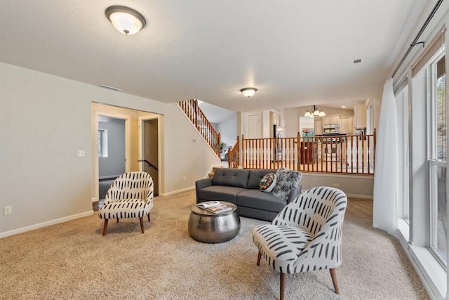 living room featuring stairway, visible vents, baseboards, light carpet, and a chandelier