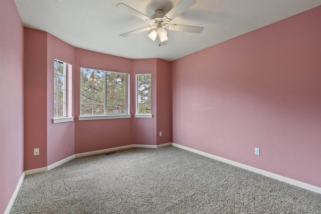 spare room featuring baseboards, a ceiling fan, and carpet floors