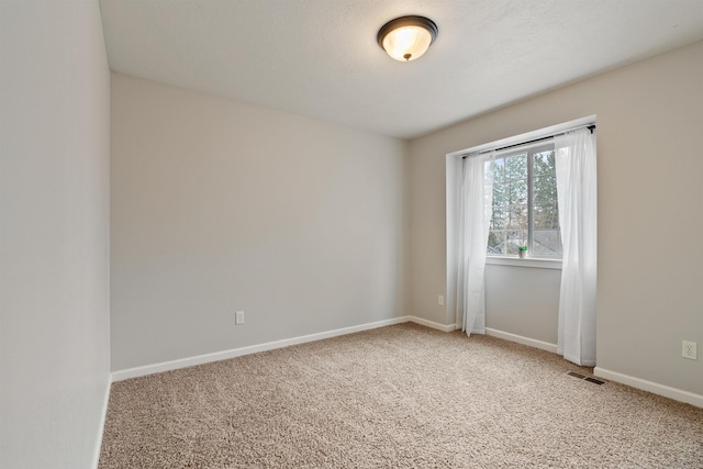 spare room with visible vents, baseboards, and carpet flooring