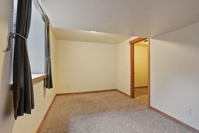 spare room with light carpet and baseboards