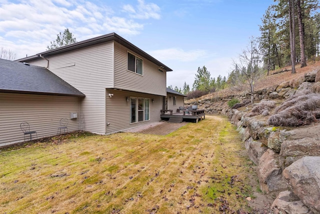 back of property featuring a lawn and a wooden deck