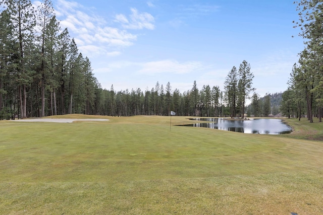 surrounding community with a lawn and a water view