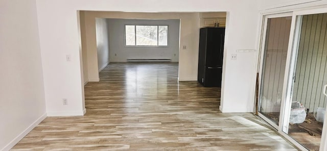 hall featuring baseboards, light wood-type flooring, and a baseboard radiator