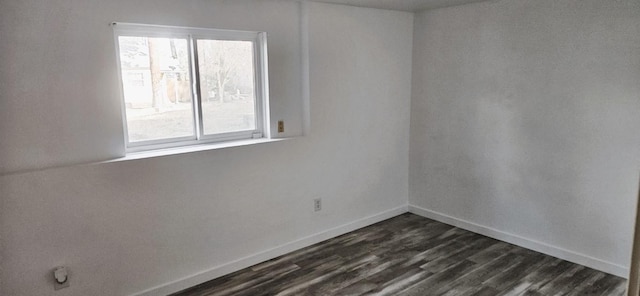 empty room with dark wood-style floors and baseboards