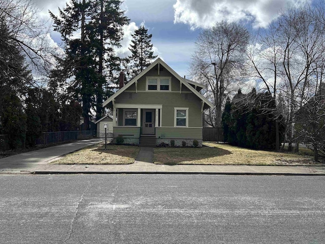 craftsman house featuring concrete driveway, a front lawn, and fence