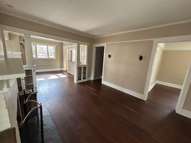 unfurnished living room featuring dark wood finished floors, ornate columns, crown molding, and baseboards