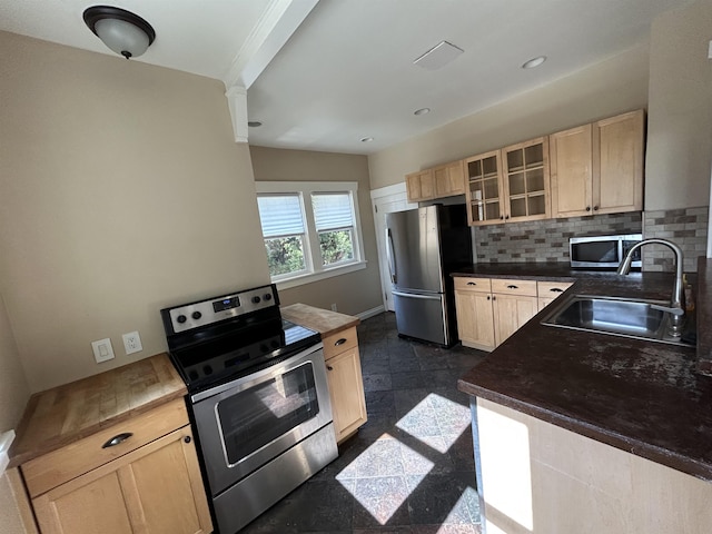 kitchen with backsplash, light brown cabinets, appliances with stainless steel finishes, granite finish floor, and a sink