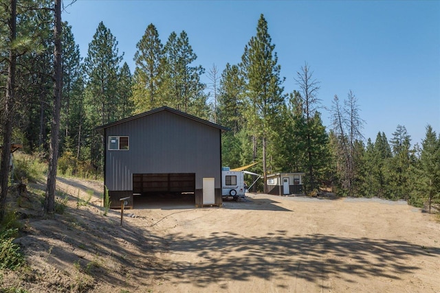 exterior space featuring a garage, an outbuilding, and driveway