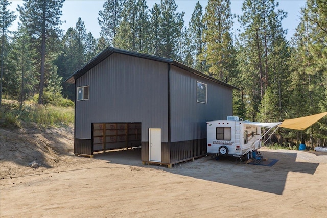 view of side of home featuring driveway and an outdoor structure