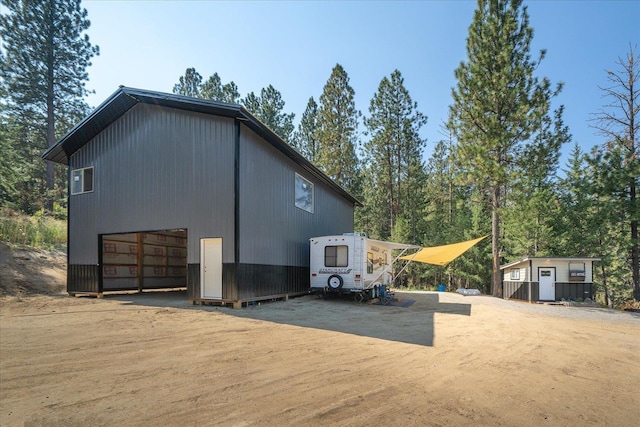 view of property exterior with an outbuilding and dirt driveway