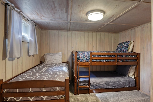 carpeted bedroom featuring wood walls