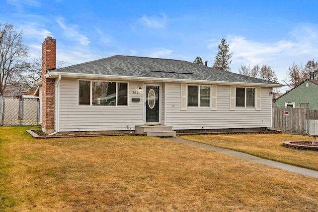 ranch-style home with a chimney, a front yard, and fence