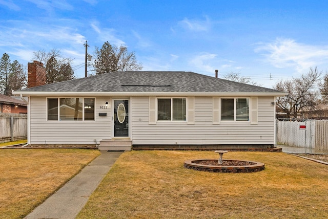 ranch-style house with roof with shingles, a front lawn, and fence