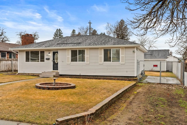 view of front of home featuring a front lawn, a gate, fence, and roof with shingles