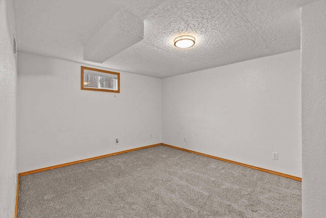 carpeted empty room with baseboards and a textured ceiling