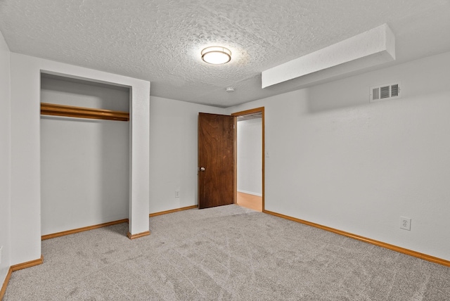 unfurnished bedroom featuring visible vents, baseboards, carpet flooring, a closet, and a textured ceiling