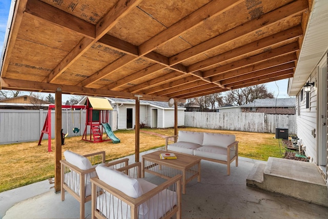 view of patio with an outdoor living space, a storage unit, an outbuilding, and a fenced backyard