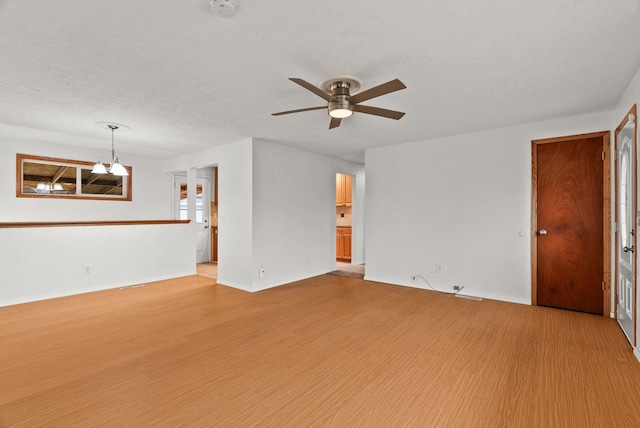 unfurnished living room with light wood-type flooring, baseboards, a textured ceiling, and a ceiling fan